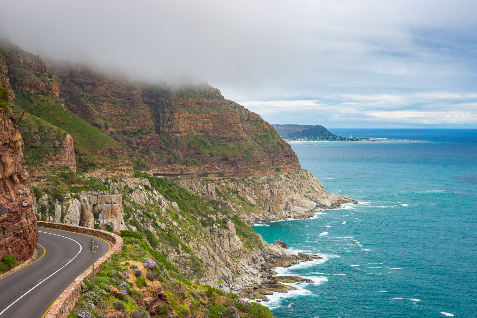 Chapman's Peak Drive, Cape Town, South Africa. Rough coastline in winter season, cloudy and dramatic sky, waving Atlantic Ocean.